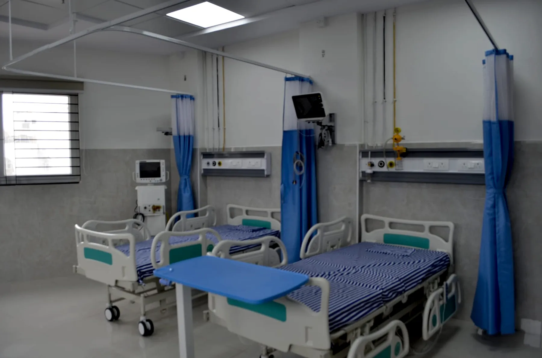 Intensive care unit beds with patient monitors and ventilator